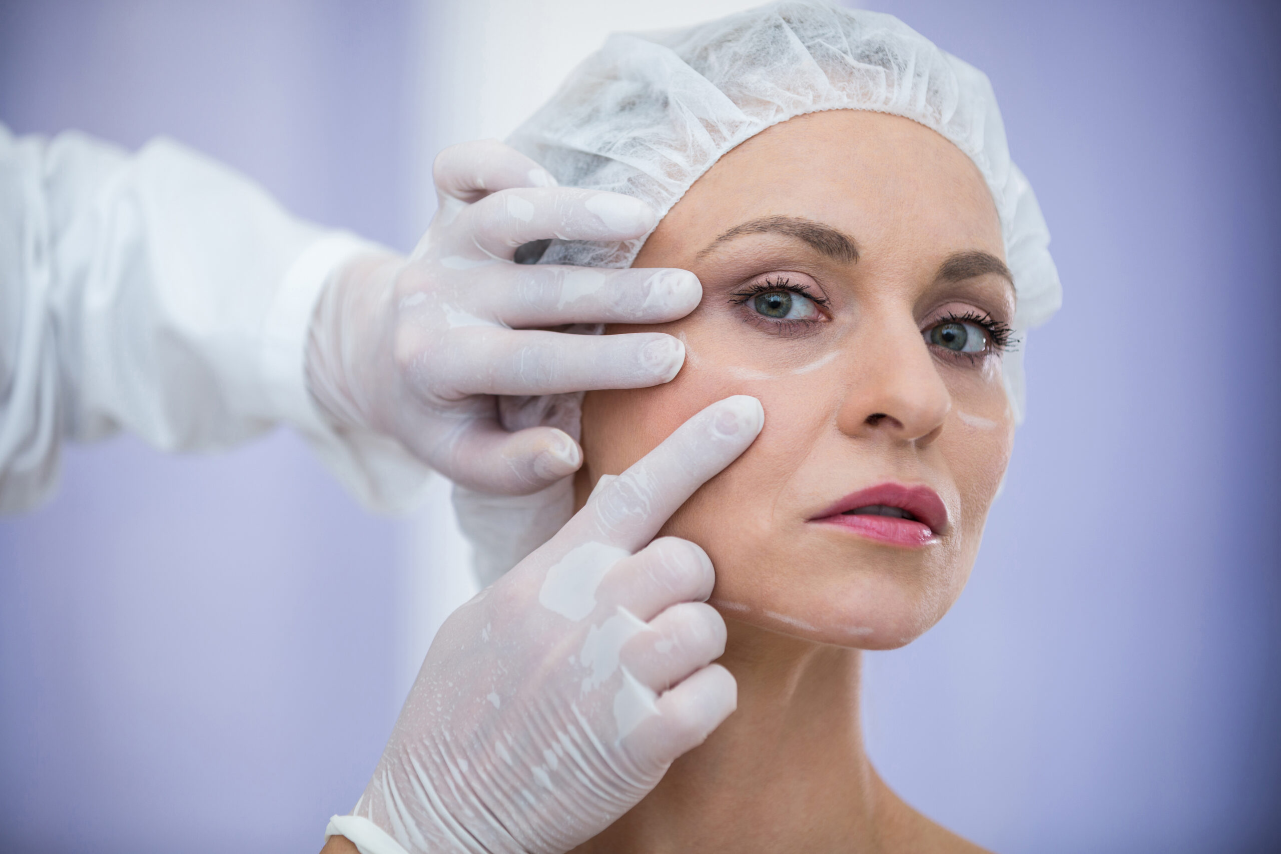 Close-up of doctor examining female patients face for cosmetic treatment