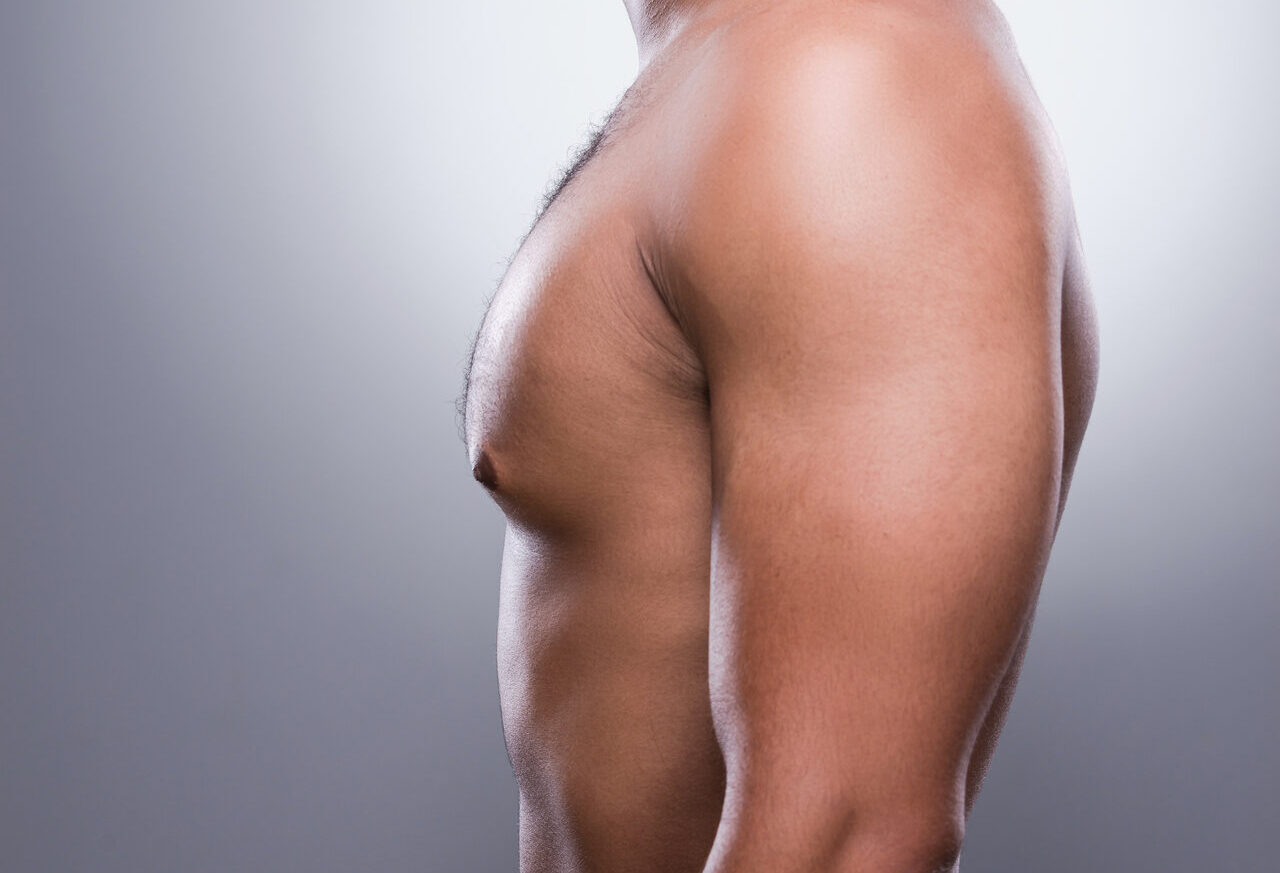 He got perfect body. Side view of young shirtless African man standing against grey background